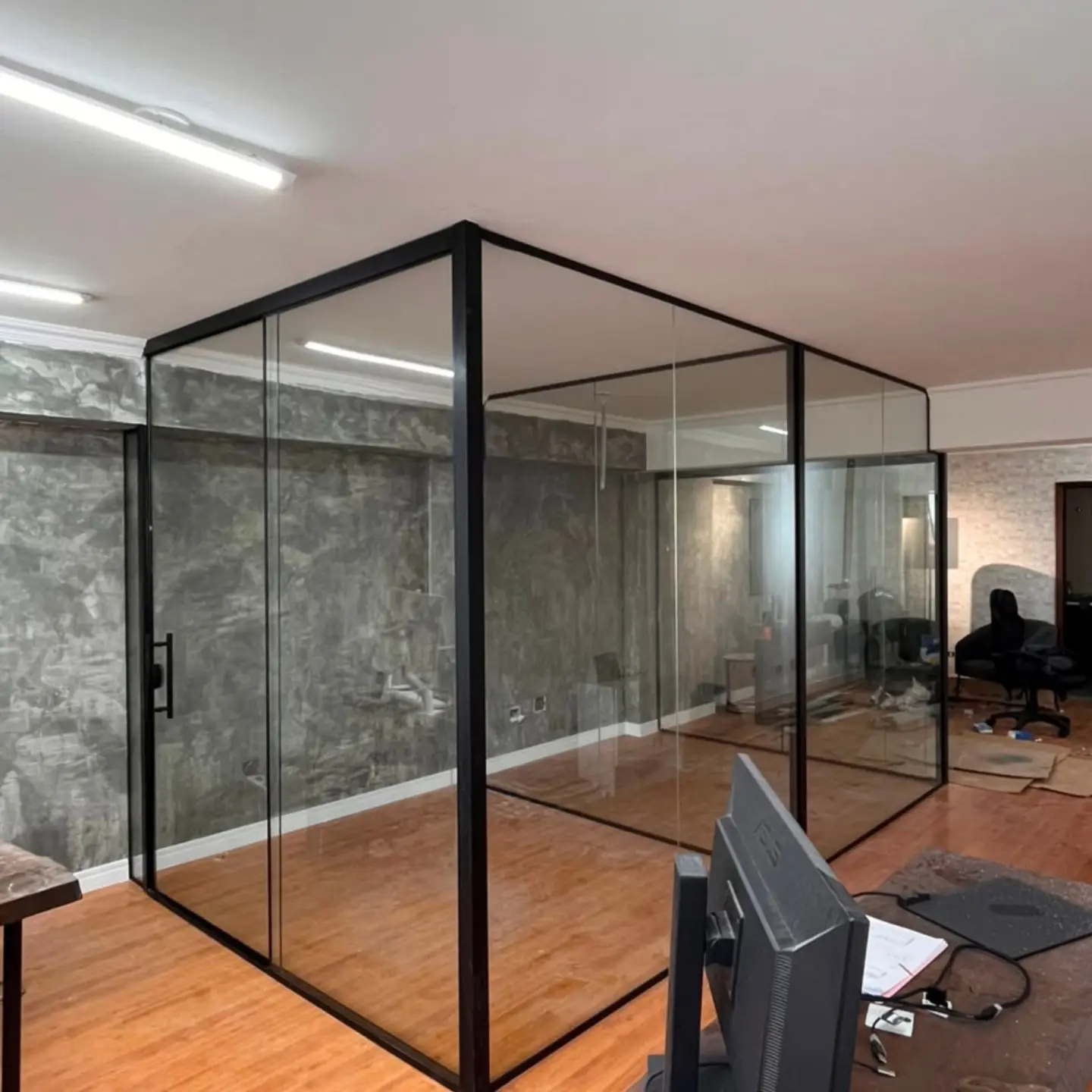 Sala de escritório fechada com divisórias de vidro e perfil preto